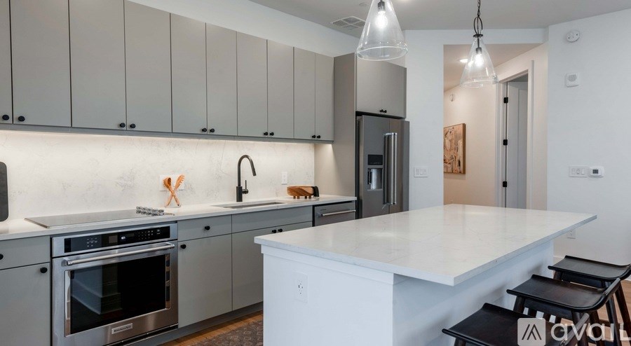 A modern kitchen with a large island and stainless steel appliances.