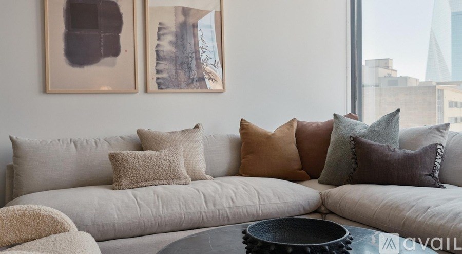 A living room with a large couch and two framed pictures on the wall.
