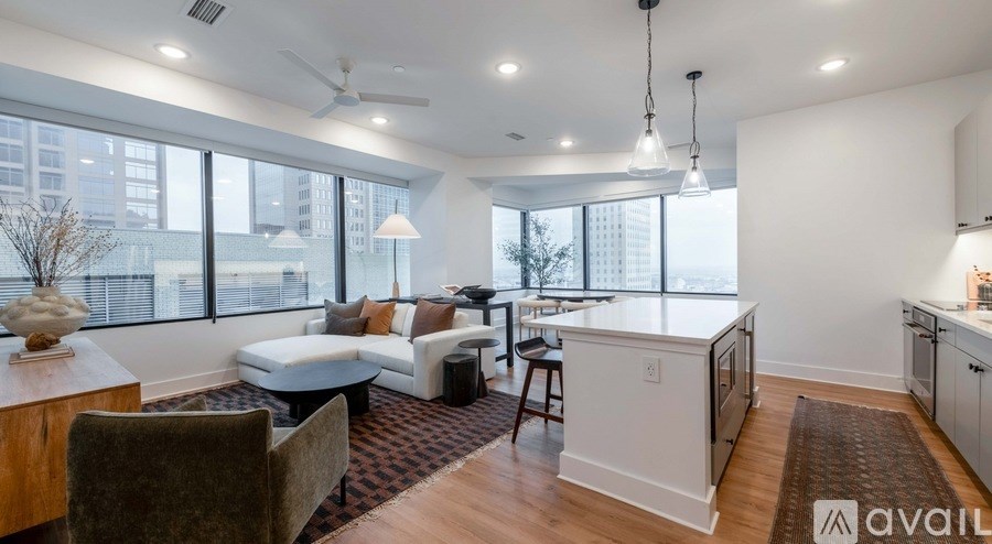 A modern kitchen and living room with a large window and a view of the city.