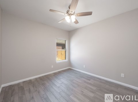 A room with a ceiling fan and a window.