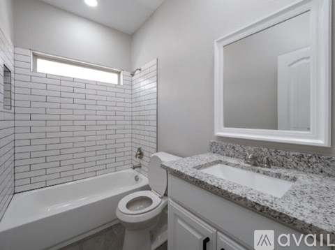 A white bathroom with a toilet, sink, and tub.