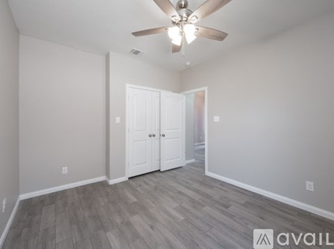 A room with a ceiling fan and two doors.