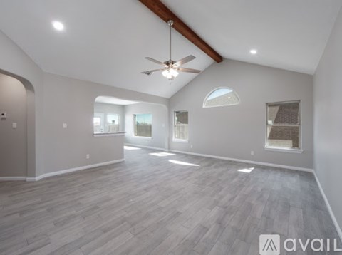 A spacious room with a ceiling fan and lighting fixtures.