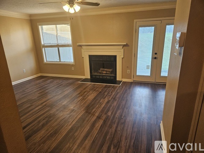 A room with a fireplace and wood flooring.