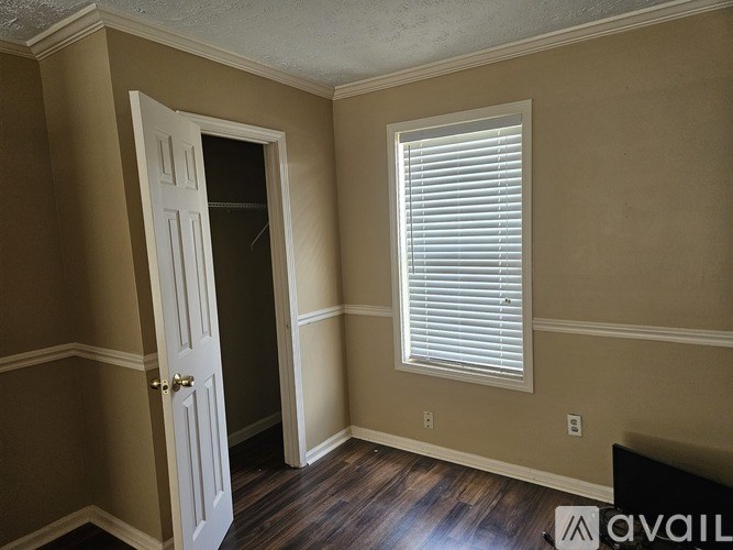 A room with a door and a window with blinds.