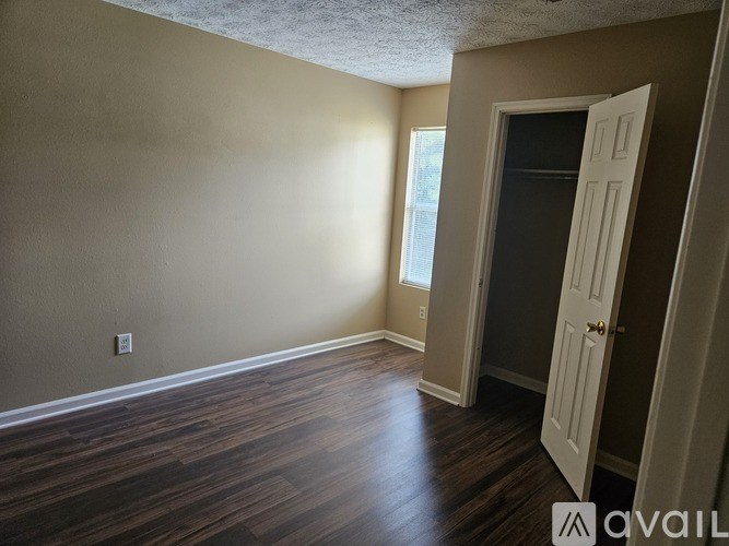A room with a wooden floor and a white door.
