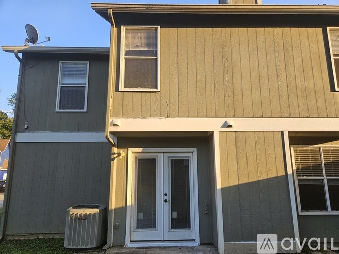 A house with a grey and beige exterior and a white door.