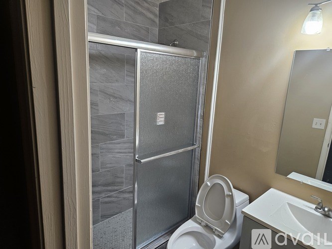 A bathroom with a toilet, sink, and shower.