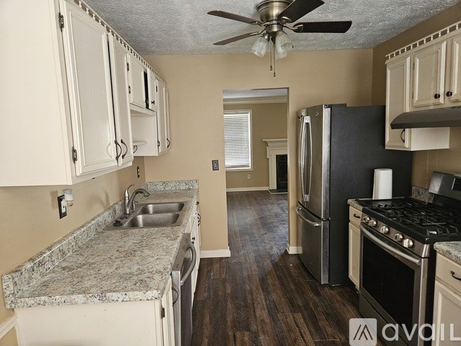 A kitchen with a marble countertop and stainless steel appliances.
