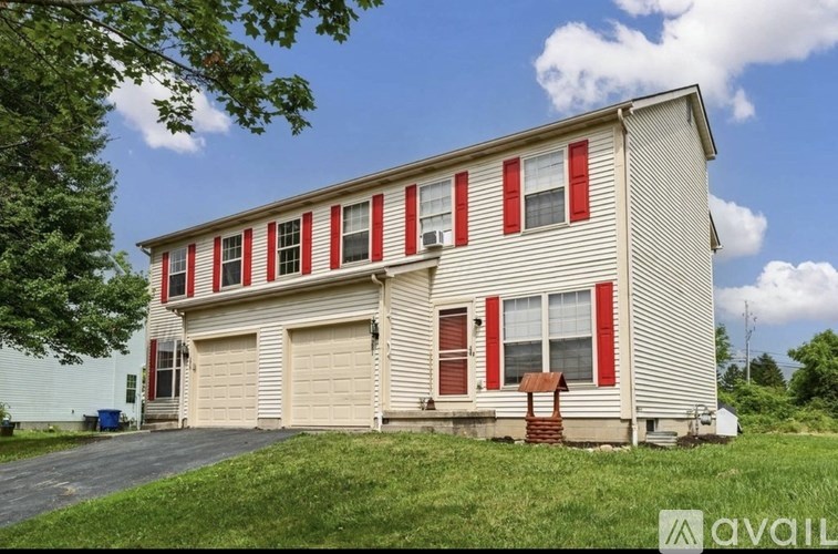 A two-story house with red shutters and a garage.
