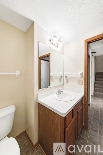 A bathroom with a white sink and a toilet.