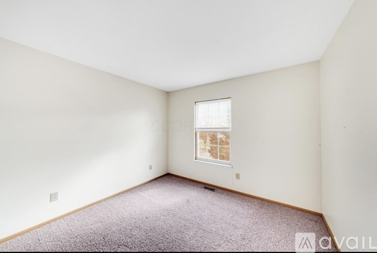 A room with a carpeted floor and a window.