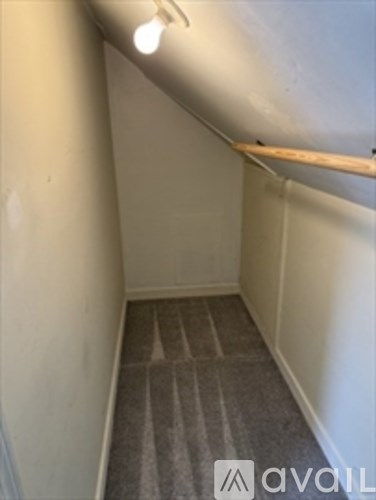 A hallway with a carpeted floor and a light on.