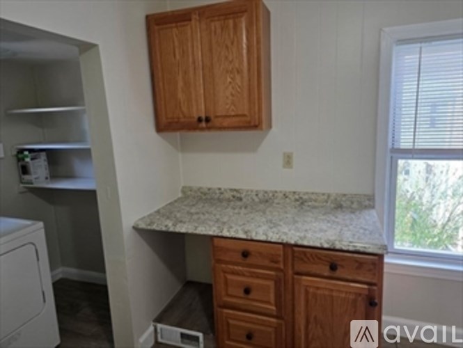 A kitchen with wooden cabinets and a granite countertop.
