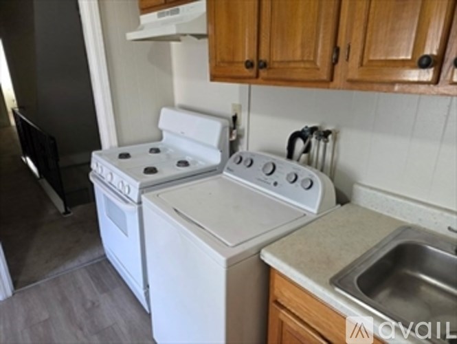 A white stove and oven in a kitchen with wooden cabinets.