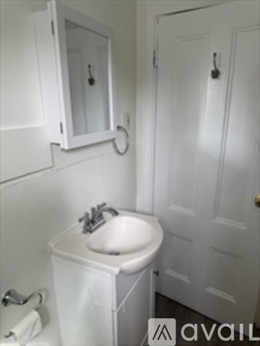 A white bathroom with a sink and mirror.