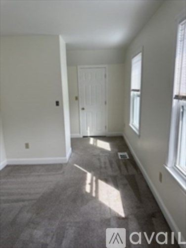 A room with a carpeted floor and a door.