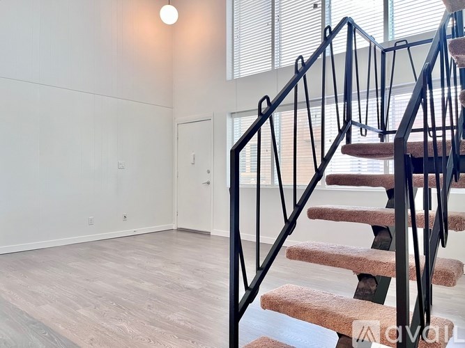 A staircase with a metal railing and wooden steps leads to a door.