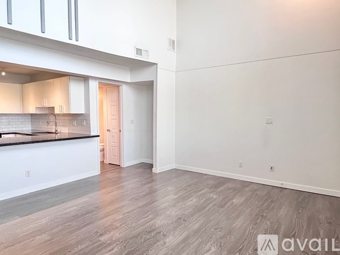 A kitchen with a black countertop and wooden flooring.