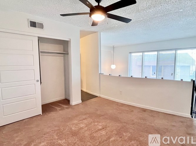 A room with a ceiling fan and a carpeted floor.