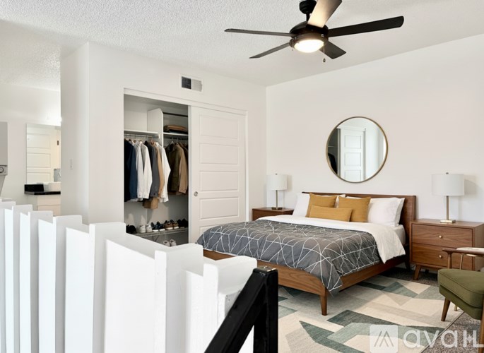 A bedroom with a bed, dresser, and mirror.