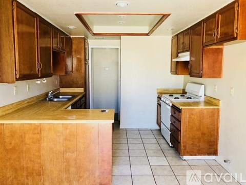 A kitchen with wooden cabinets and a wooden island with a sink.