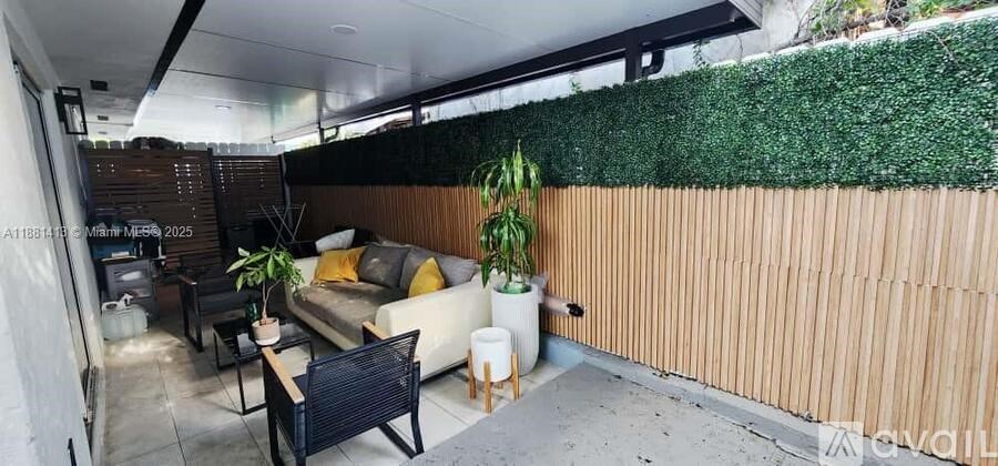 A living room with a couch, chairs, and a green wall.