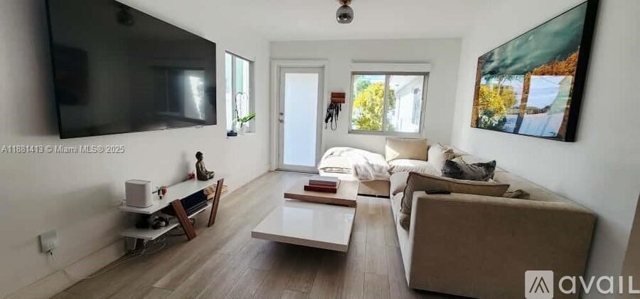 A living room with a couch, a coffee table, and a television.