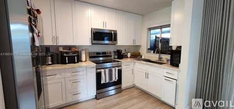A kitchen with white cabinets and stainless steel appliances.