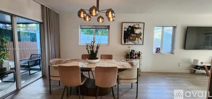A dining room with a table set for six and a television mounted on the wall.