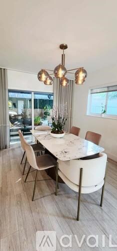 A modern dining room with a white table and chairs.
