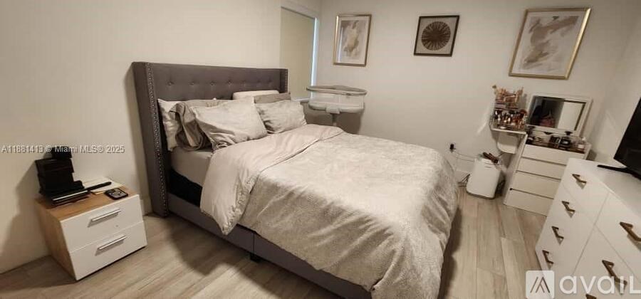 A well-lit bedroom with a large bed, a nightstand, and a TV.