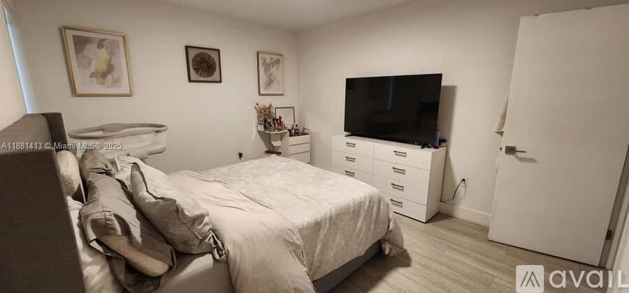 A bedroom with a bed, dresser, and television.