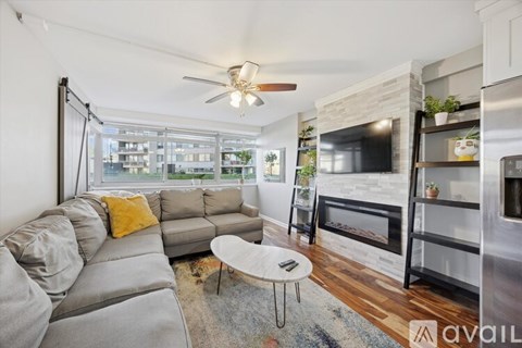 A modern living room with a grey sofa and a fireplace.