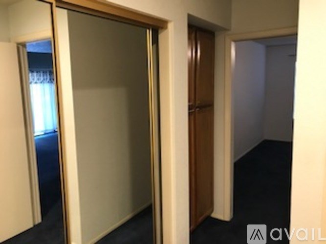A hallway with a glass door and a wooden door.