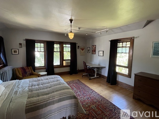 A bedroom with a bed, desk, and chair.