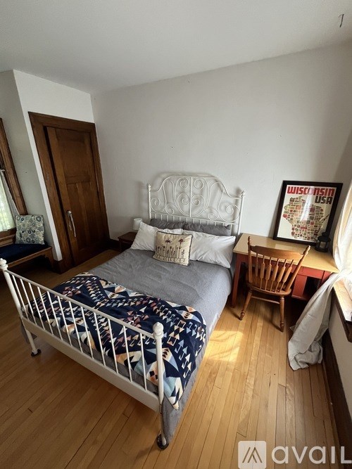 A bedroom with a bed, chair, and poster on the wall.