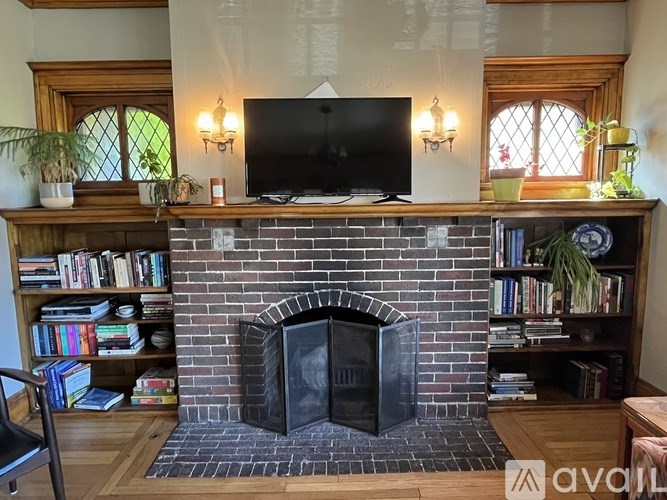 A fireplace with a TV above it and a bookshelf on either side.