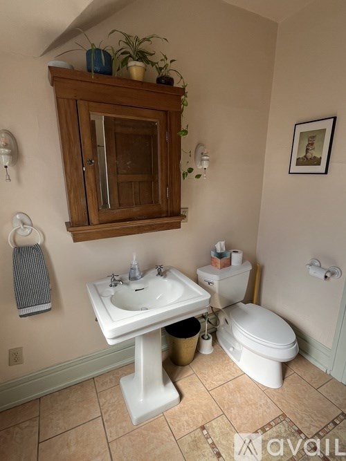 A bathroom with a white pedestal sink and a white toilet.