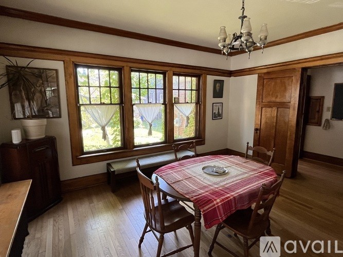A dining room with a table set for two and a chandelier.