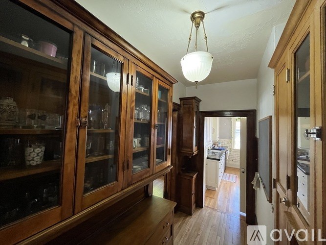 A kitchen with wooden cabinets and a hanging light fixture.