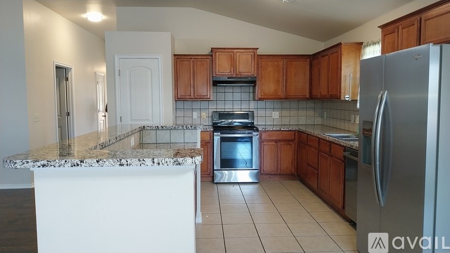 A kitchen with a marble countertop and stainless steel appliances.