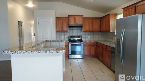A kitchen with a marble countertop and stainless steel appliances.