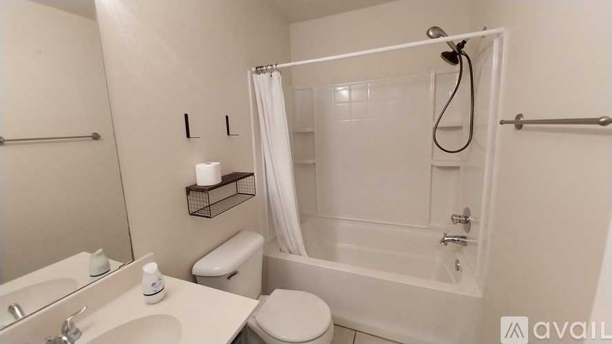 A white bathroom with a toilet, sink, and bathtub.