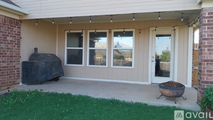 A patio with a grill and a covered table.