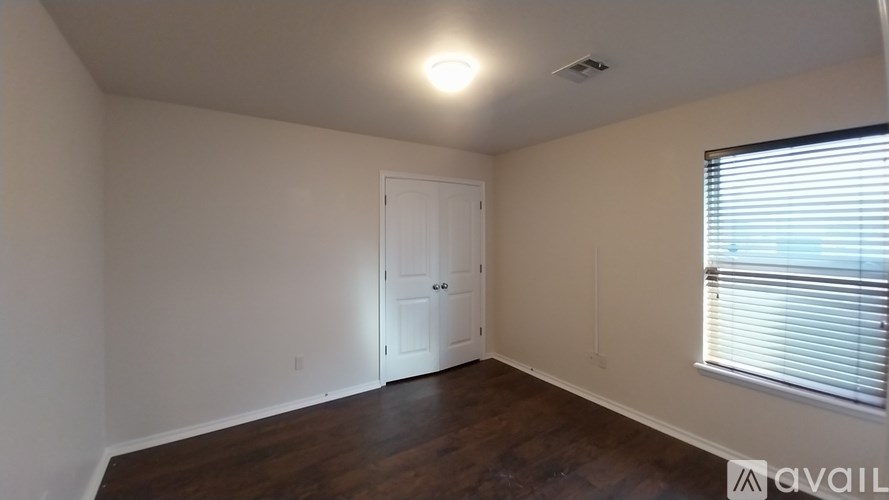 A room with a white door and a window with blinds.
