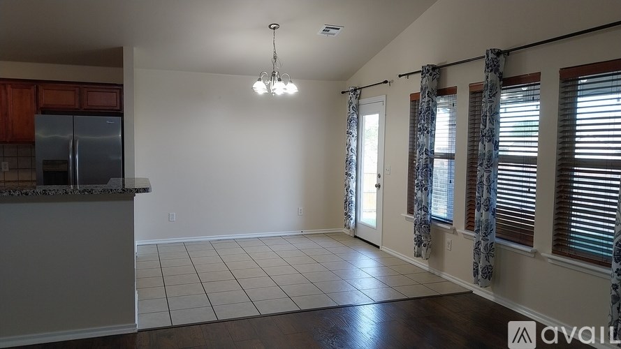 A kitchen with a refrigerator, cabinets, and a countertop is available for rent.