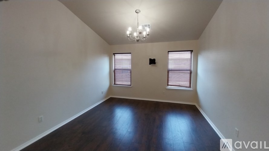 A room with wooden floors and a chandelier.