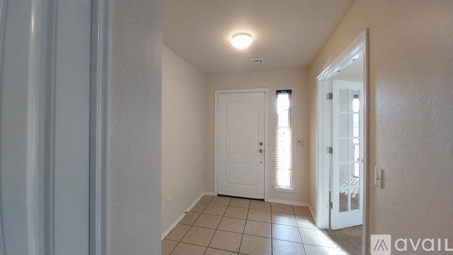 A room with a white door and a tiled floor.