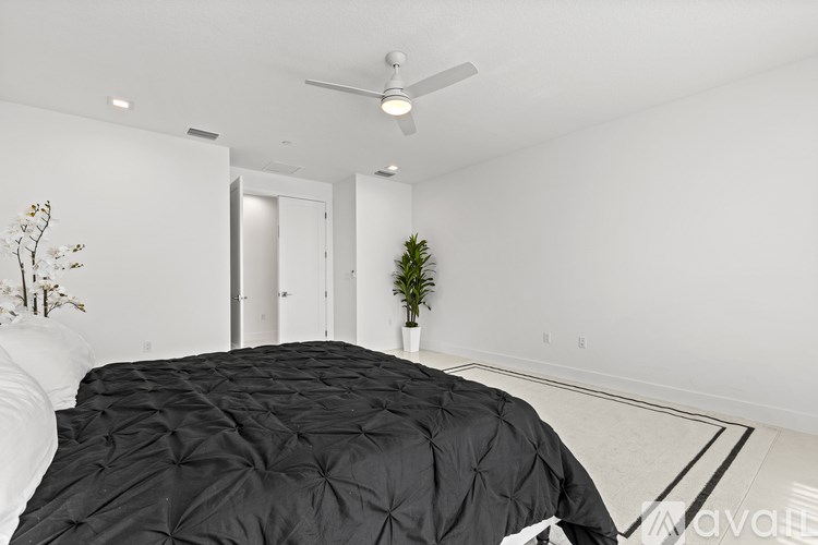 A bedroom with a large bed and a ceiling fan.
